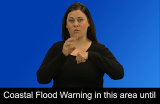 Woman on blue background using American Sign Language. Caption reads: "Coastal Flood Warning in this area until..."