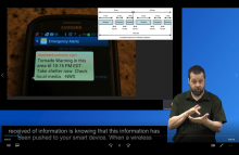 Screenshot of video playing, shows photo of mobile phone receiving a tornado warning, the WEA vibrating cadence, ASL interpreter, and captions.